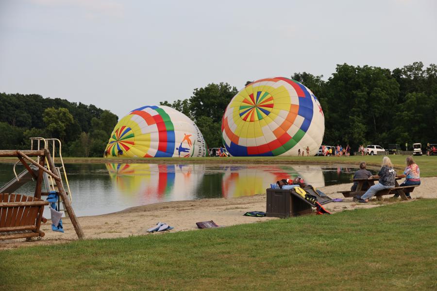 two balloons getting inflated by the pond