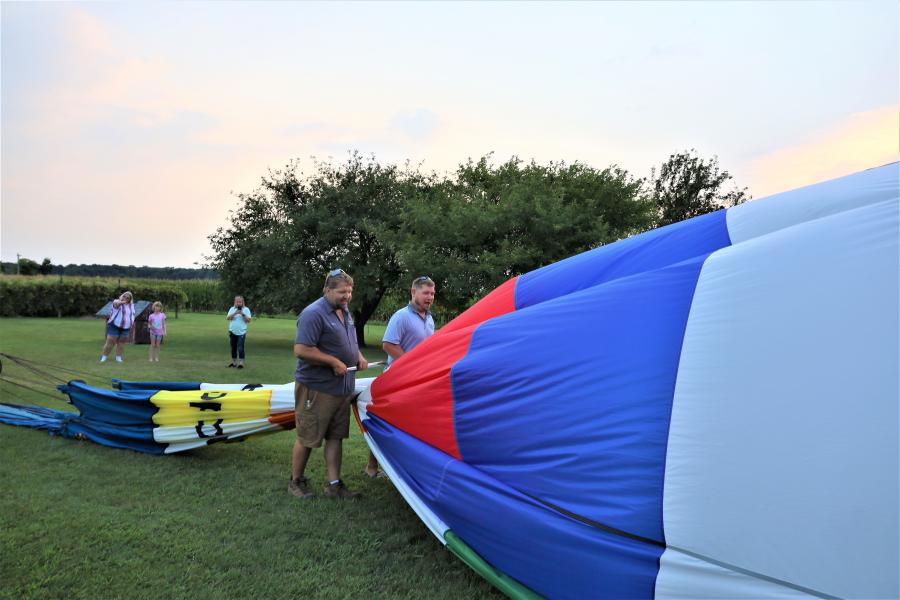 men squeezing the air out of the balloon