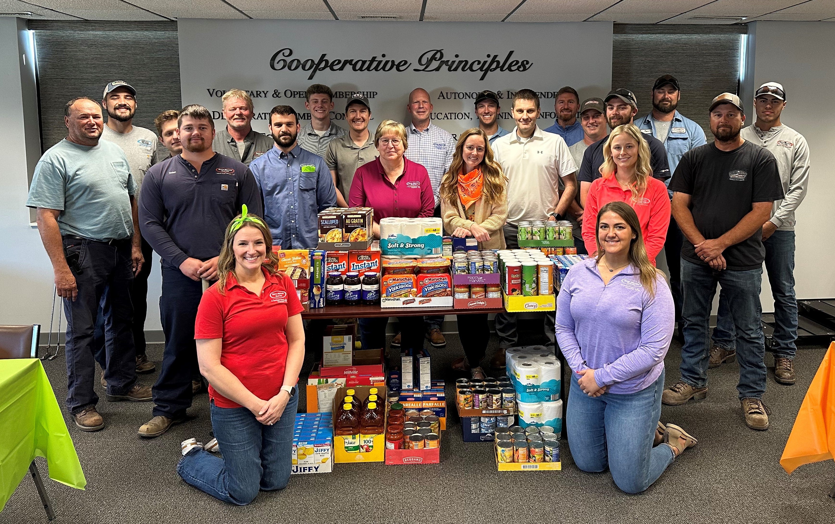 Employees posing with food donation items