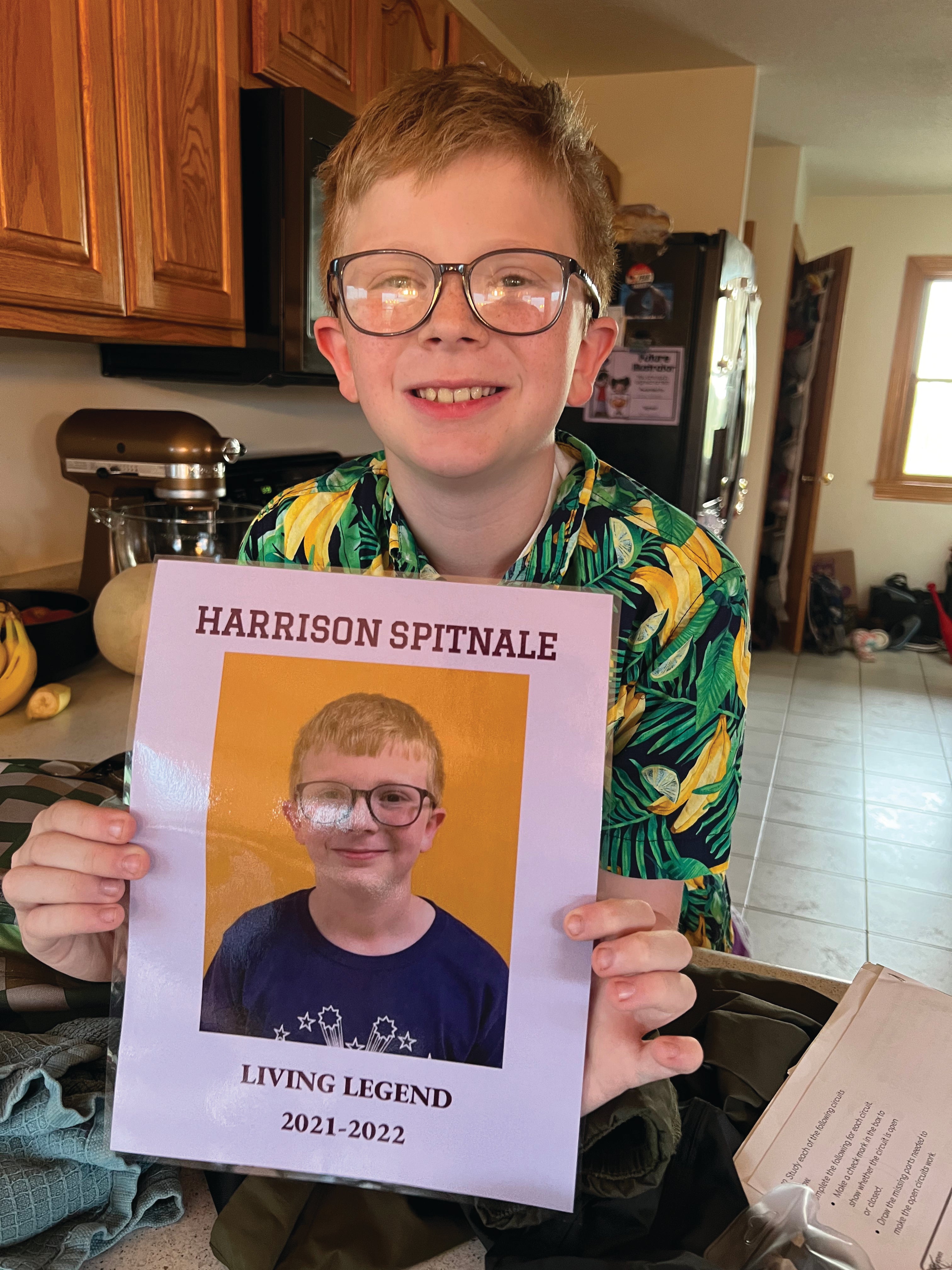 boy with glasses holding poster