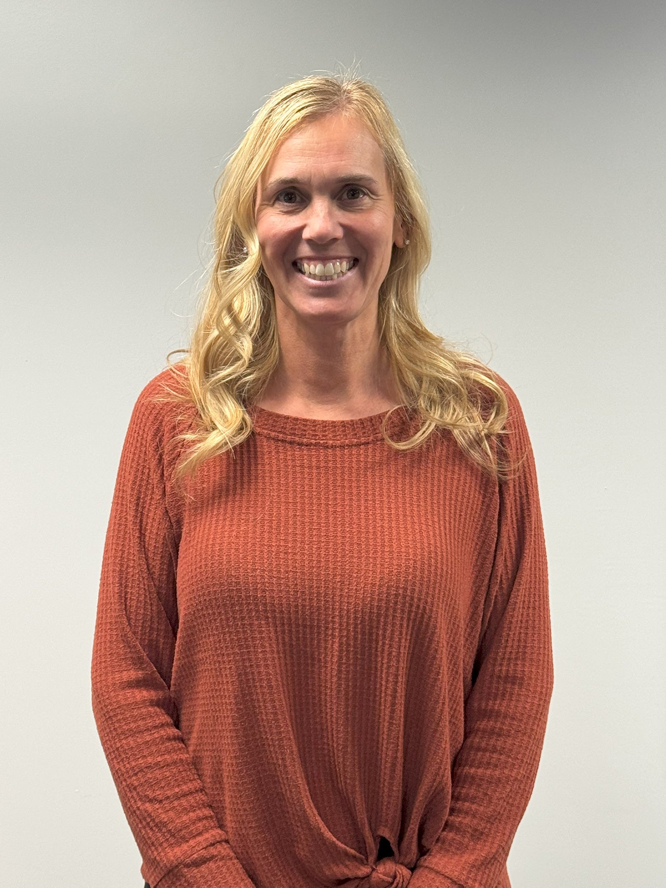 lady with blonde hair and rust sweater