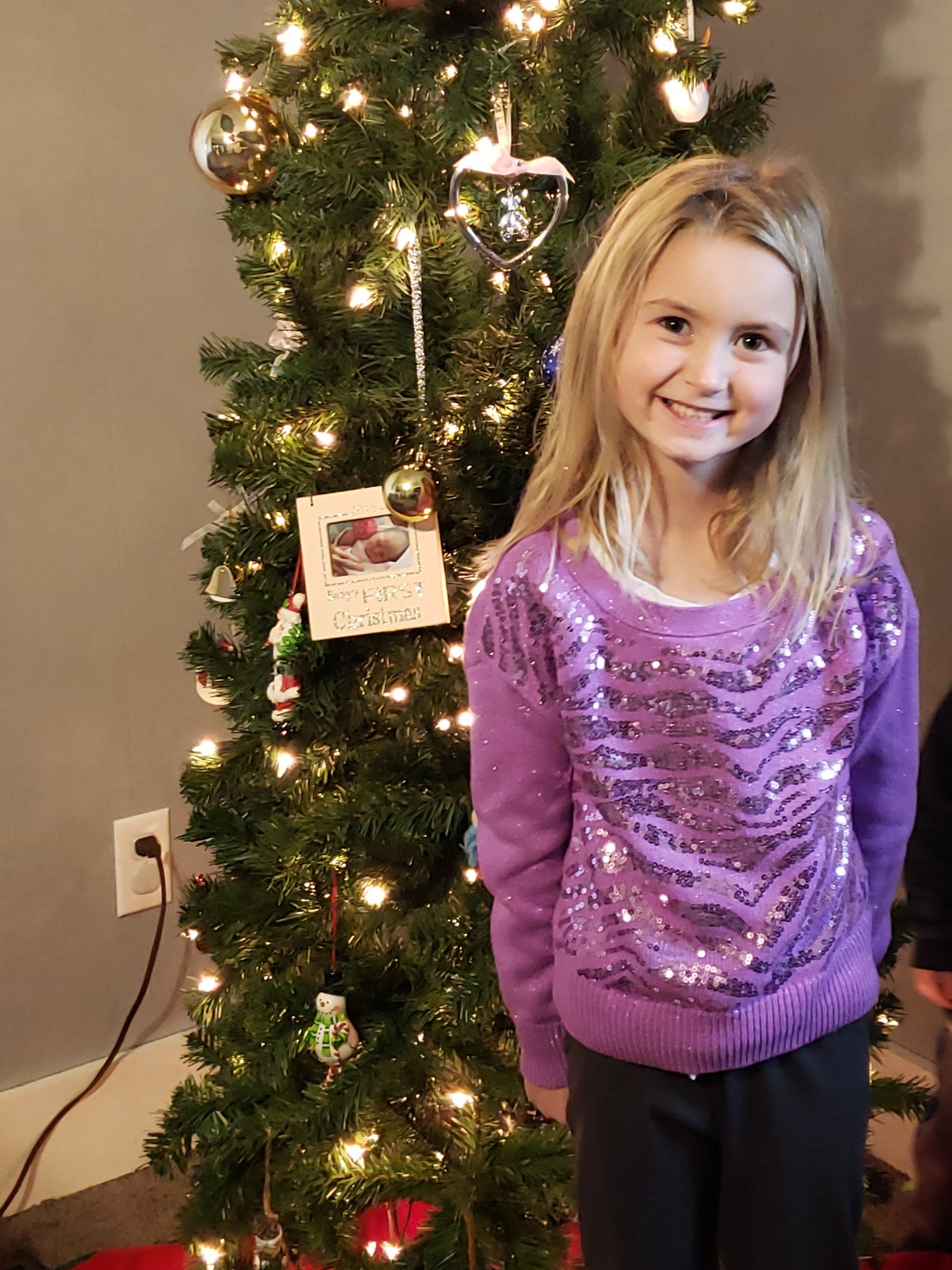 Molly Kuney standing by Christmas Tree