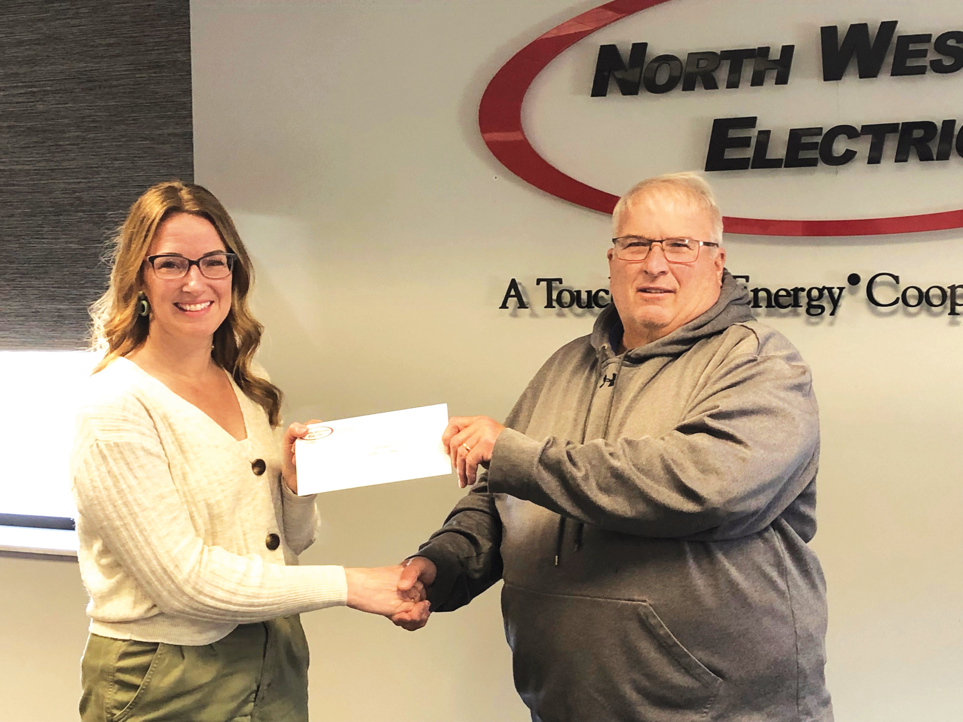 NWEC’s Director of Human Resources Tracey Carter presents Defiance County Agricultural Society President Jerry Sanders with the $1,050 donation.