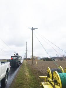 Lineman stringing wire on a pole